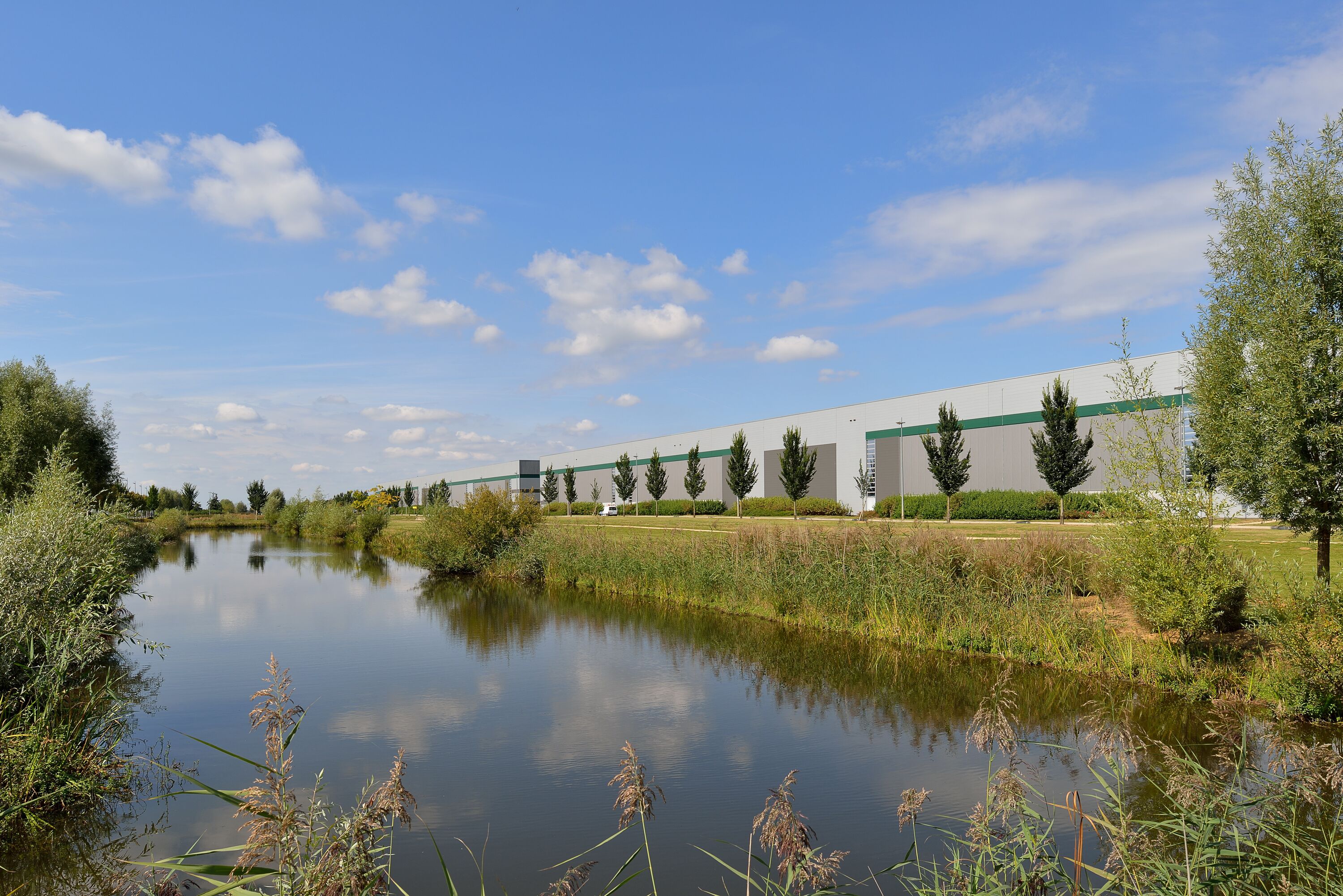 Un entrepôt avec des arbres et une rivière en arrière-plan